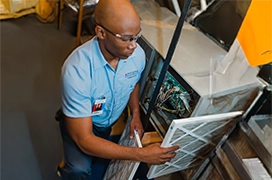 An Aire Serv technician replacing an air filter.