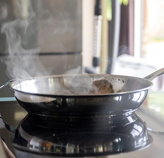 Pan on stove top with cooking gasses.