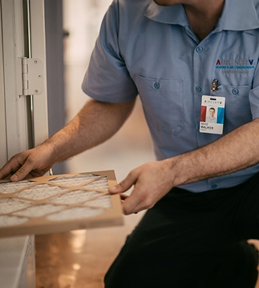 Aire Serv tech installing filter.