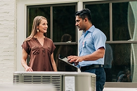 Aire Serv tech meeting outside with customer to discuss HVAC system.