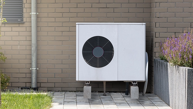 A heatpump installed beside a wall.