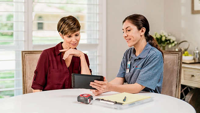 Aire Serv technician showing tablet to customer.
