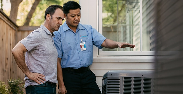 An Aire Serv technician explaining services to client.