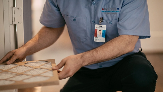 An Aire Serv technician explaining services to client.