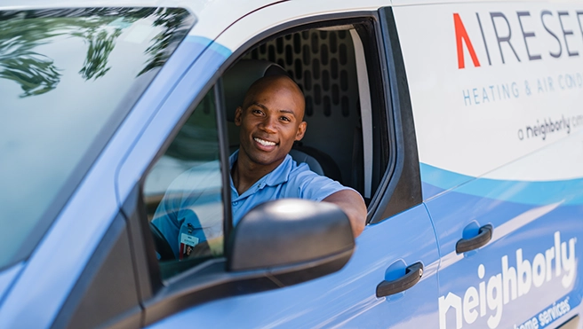 An asv technician smiling looking out of window.