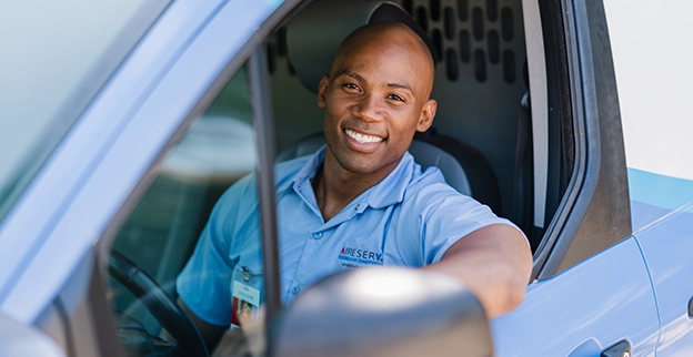 Smiling Aire Serv tech in work van.