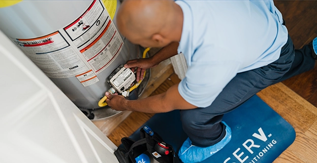 Aire Serv technician working on the water heater.