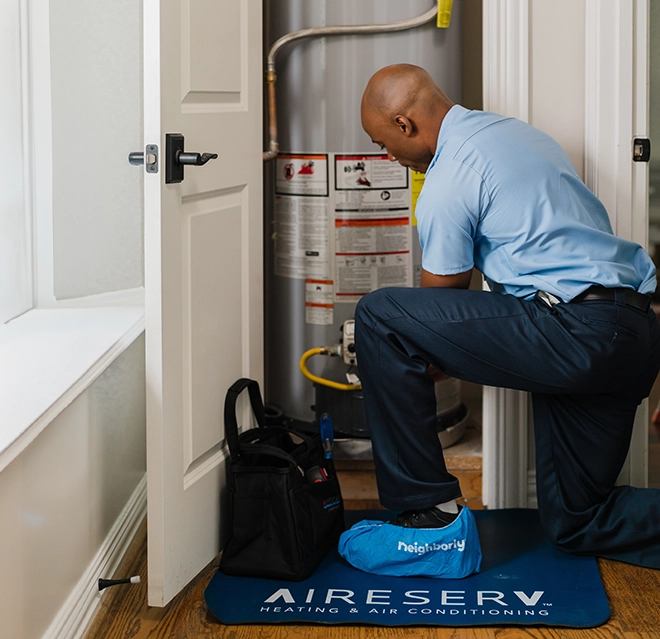 Aire Serv technician repairing a water heater.