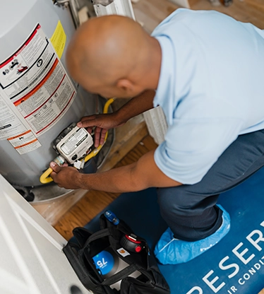 AireServ tech maintaining a water heater.