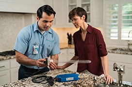 Aire serv technician explaining functions of the ultraviolet lamp.