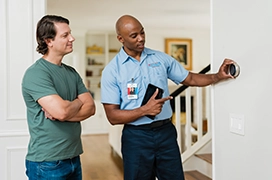 Aire Serv technician explaining thermostat to customer.