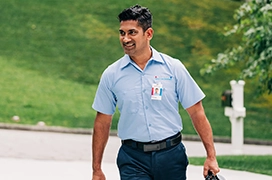 Smiling, walking Aire Serv technician.