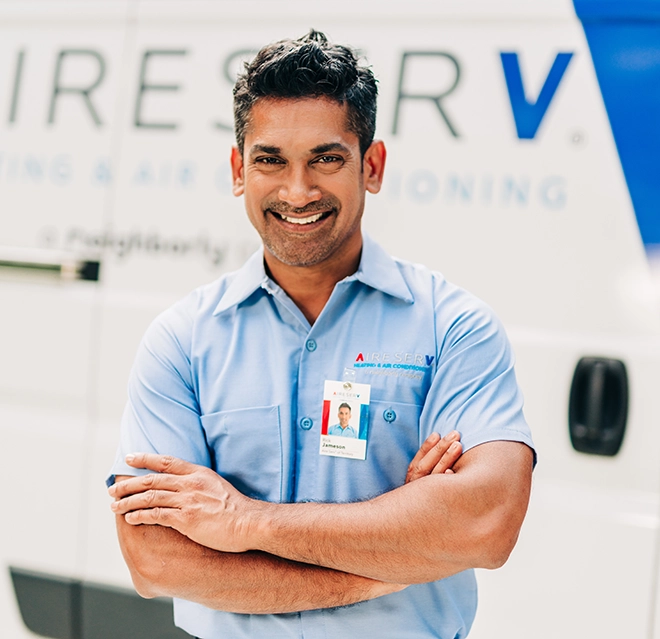Aire Serv professional standing in front of a van.