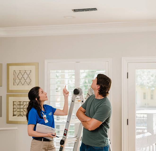 Aire Serv professional looking at roof with client.