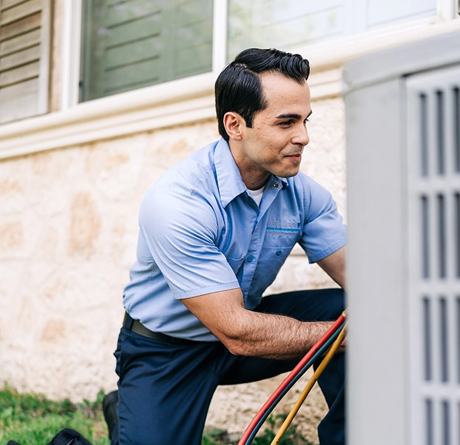 Aire Serv professional working in an air conditioner.