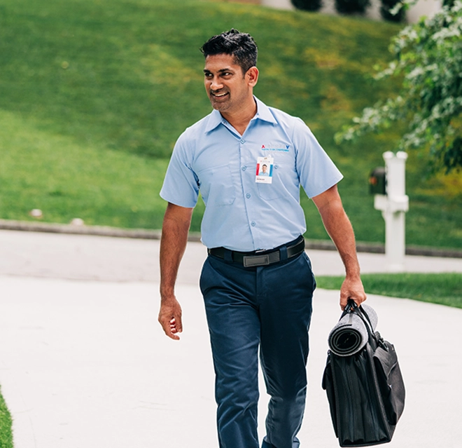 Aire Serv professional walking with a bag.