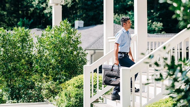 Aire Serv service professional walking up to the home of an Aire Serv Client.