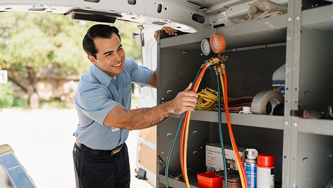 Aire Serv Professional working on a heating and cooling system.