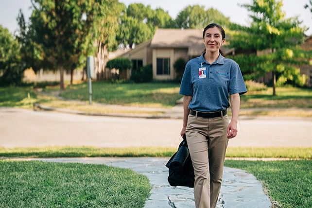Aire Serv professional walking with an Aire Serv toolbag.